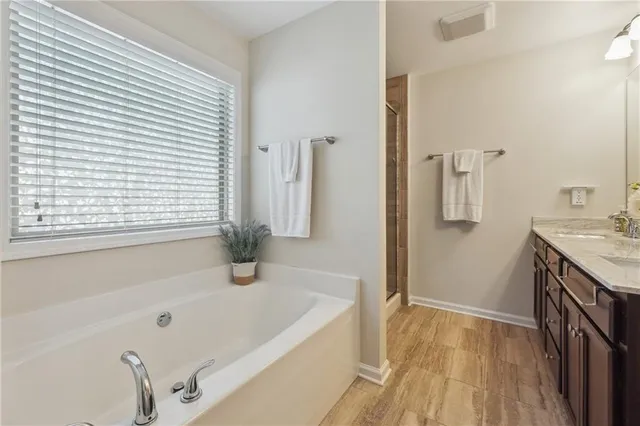 a bathroom with a tub sink and mirror