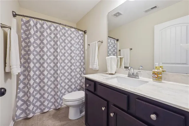 a bathroom with a granite countertop sink a toilet and a mirror