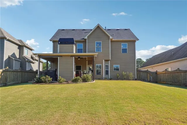 a front view of house with yard and trees in the background