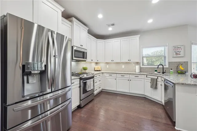a kitchen with granite countertop a refrigerator stove and sink
