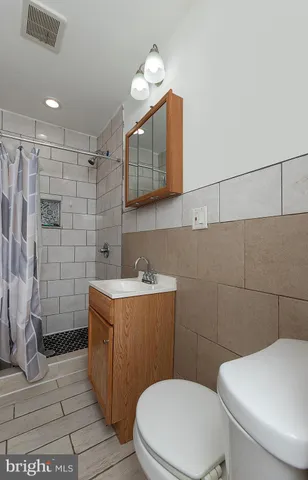 a bathroom with a sink a toilet and mirror