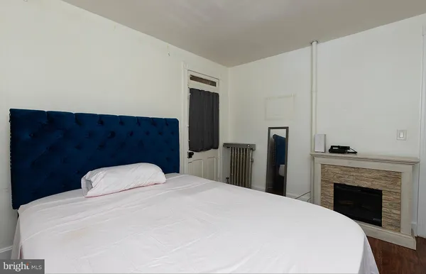 a bedroom with a large bed and a fireplace