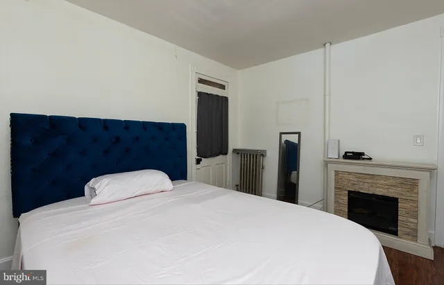 a bedroom with a large bed and a fireplace