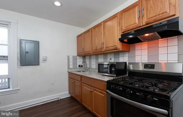 a kitchen with stainless steel appliances granite countertop a stove a sink and a microwave