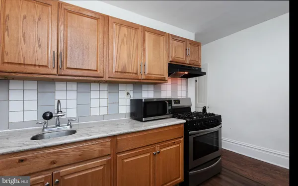 a kitchen with stainless steel appliances granite countertop a sink a stove and a microwave