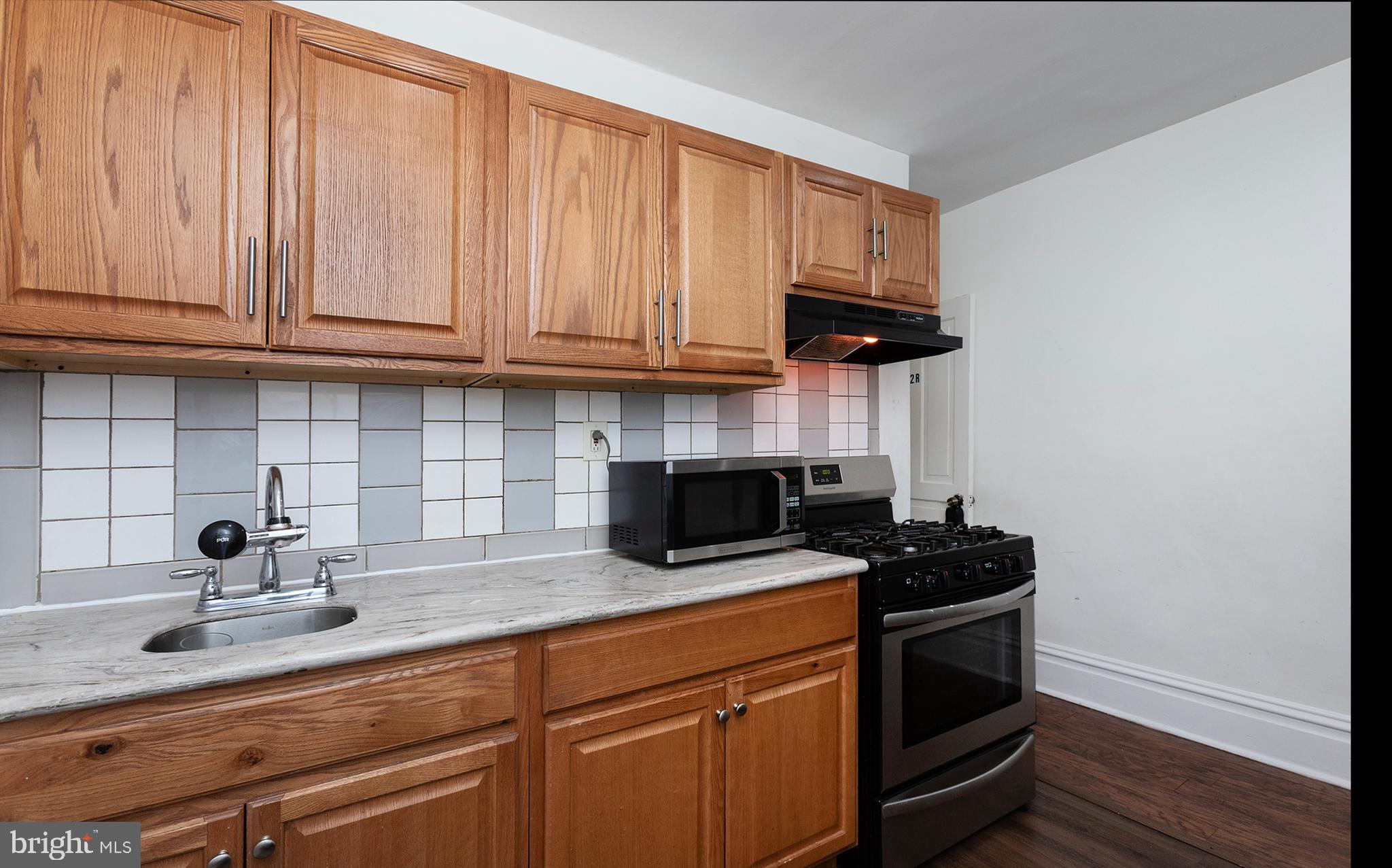 1342 State Street, Unit 2R Harrisburg, PA 17103 - Photo 9 of 17 a kitchen with stainless steel appliances granite countertop a sink a stove and a microwave