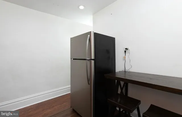 a kitchen with a refrigerator and a wooden floor