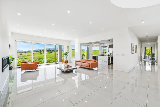 a kitchen with stainless steel appliances kitchen island granite countertop a refrigerator a stove a sink a dining table and chairs