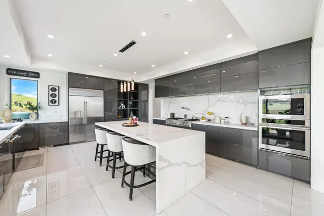 a kitchen with stainless steel appliances a sink a stove and a wooden cabinets