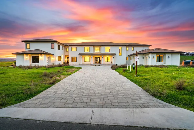 a view of a house with a yard and a fountain