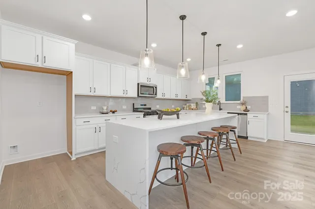 a kitchen with white cabinets and stainless steel appliances