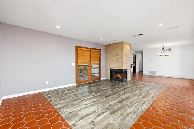 a view of an empty room with a fireplace and a window