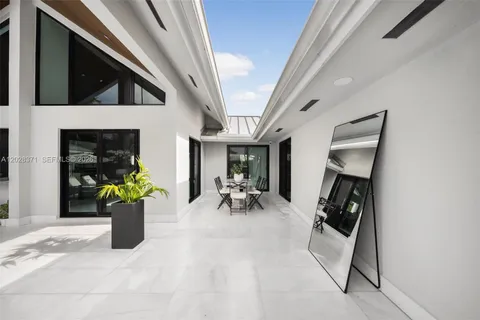 a living room with patio furniture and a potted plant