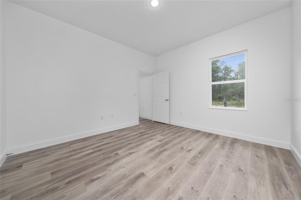 13069 Southwest 35th Circle Ocala, FL 34473 - Photo 16 of 41 a view of an empty room with wooden floor and a window