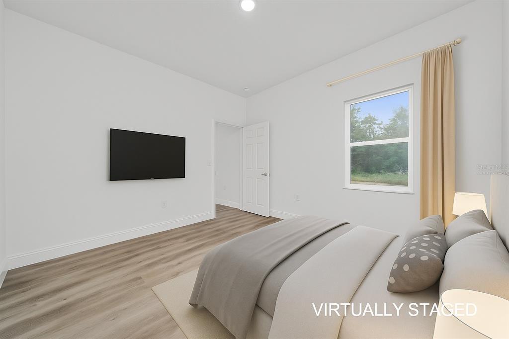 13069 Southwest 35th Circle Ocala, FL 34473 - Photo 17 of 41 a bedroom with a large bed and a flat screen tv