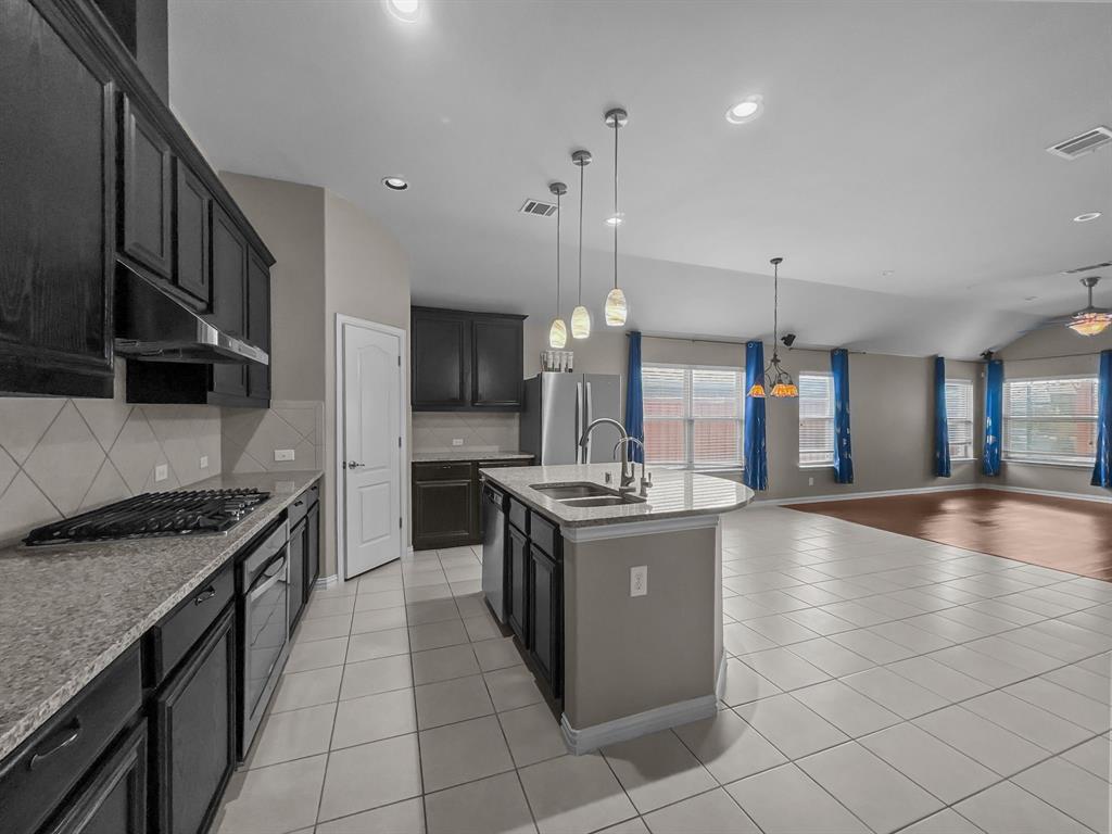 3205 Ridgeway Drive McKinney, TX 75071 - Photo 9 of 27 a kitchen with stainless steel appliances granite countertop a stove a sink and a refrigerator