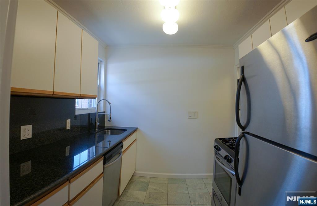 63 West Hudson Avenue, Unit C5 Englewood, NJ 07631 - Photo 9 of 19 a kitchen with a sink a refrigerator and cabinets