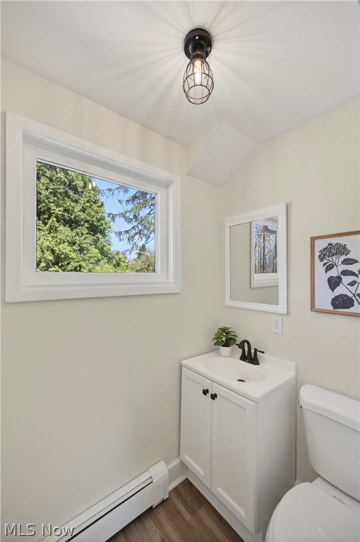 14939 Caves Road Novelty, OH 44072 - Photo 19 of 42 Bathroom with a baseboard heating unit, vanity, dark wood finished floors, and vaulted ceiling