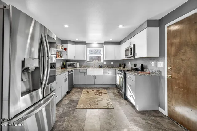 a kitchen with white cabinets and stainless steel appliances