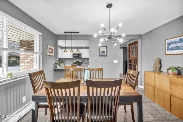 a bedroom with a large bed chandelier and a window