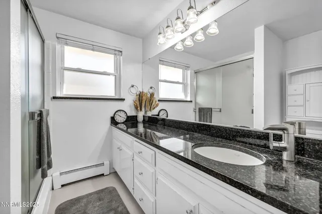 a bathroom with a toilet a sink a mirror and a window