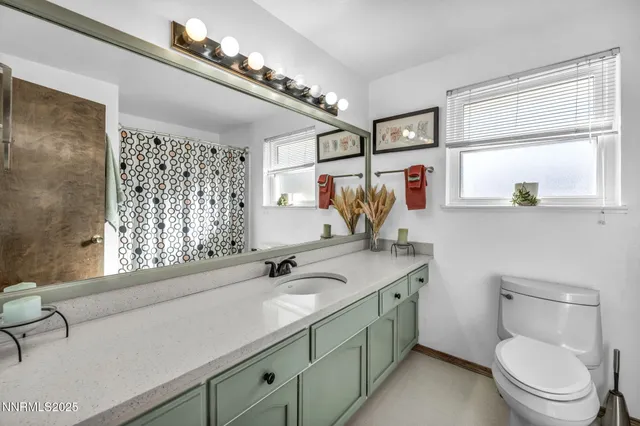 a en suite bathroom with a granite countertop sink and a mirror