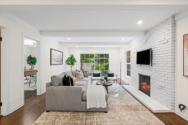 a living room with furniture a fireplace and a flat screen tv