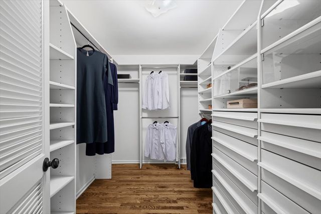 a view of walk in closet with wooden floor and closet