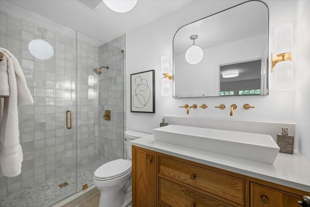 a bathroom with a sink mirror vanity and toilet
