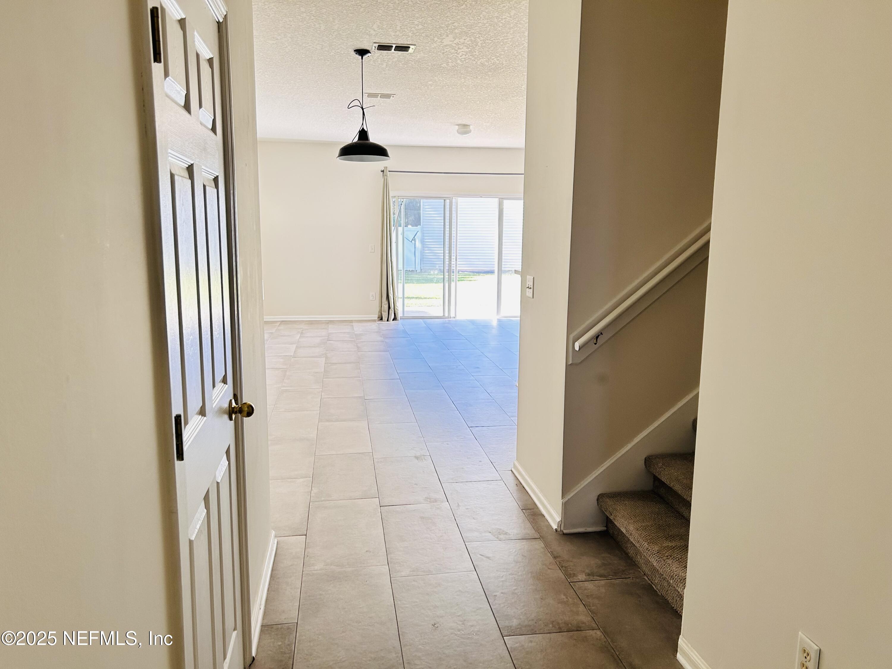 8617 Ribbon Falls Lane Jacksonville, FL 32244 - Photo 4 of 16 a view of a hallway with wooden floor and staircase