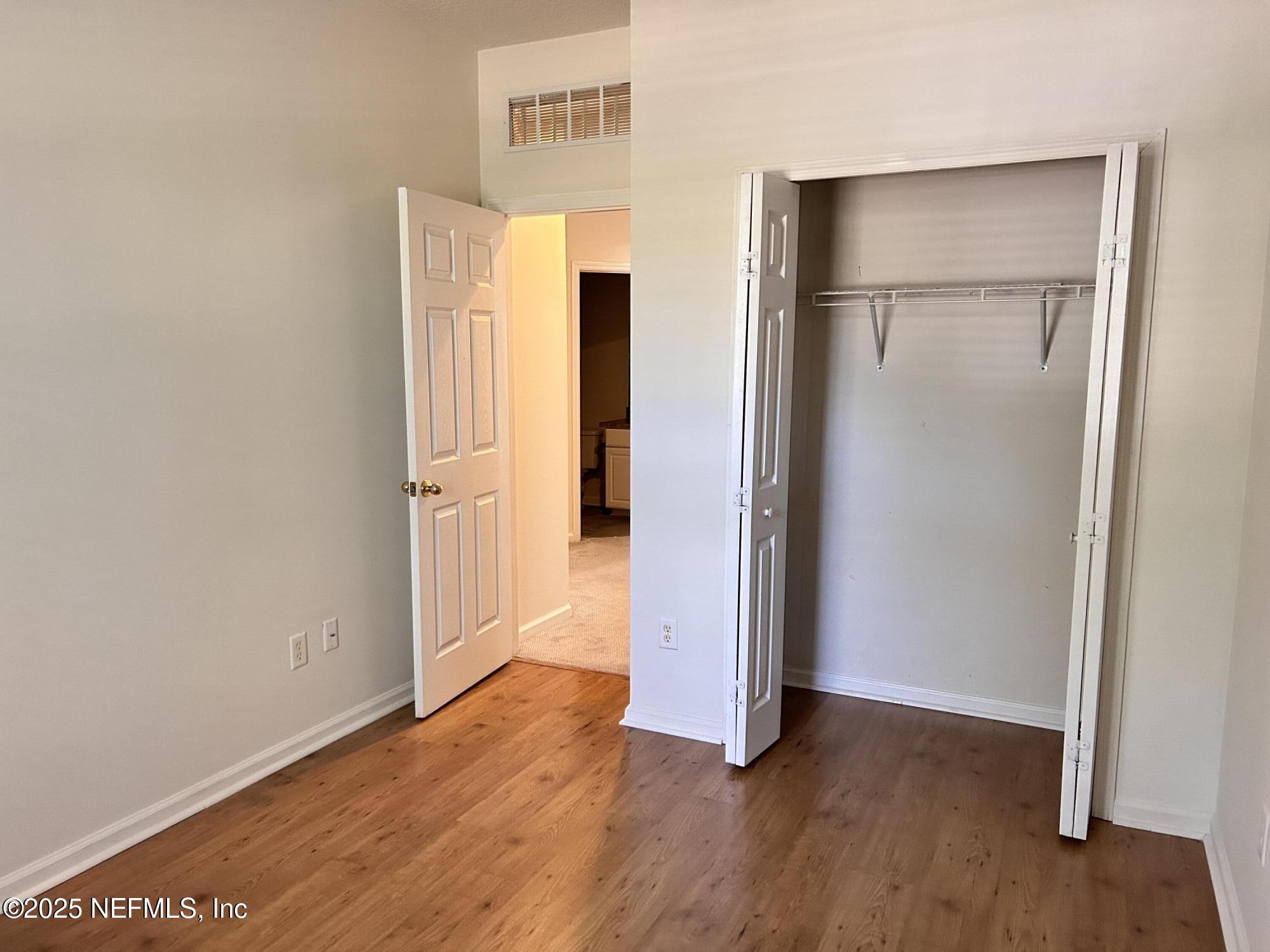 8617 Ribbon Falls Lane Jacksonville, FL 32244 - Photo 10 of 16 an empty room with wooden floor and closet