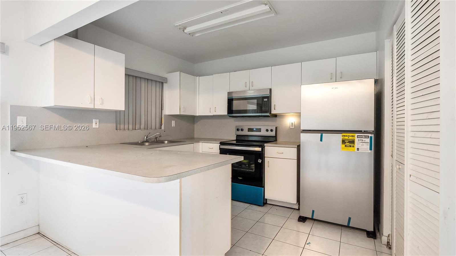 11405 Southwest 148th Terrace Miami, FL 33176 - Photo 11 of 28 a kitchen with stainless steel appliances a refrigerator a sink and a stove