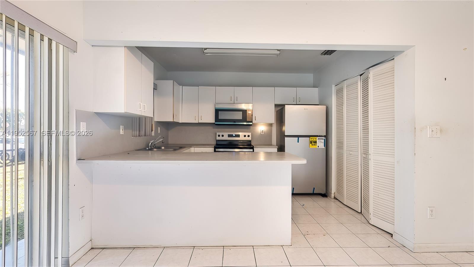 11405 Southwest 148th Terrace Miami, FL 33176 - Photo 10 of 28 a kitchen with stainless steel appliances a refrigerator sink and microwave