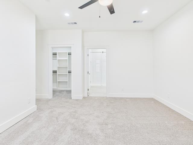 511 Richardson Street Athens, TX 75751 - Photo 18 of 40 Unfurnished bedroom with a walk in closet, light colored carpet, a ceiling fan, ensuite bath, and recessed lighting