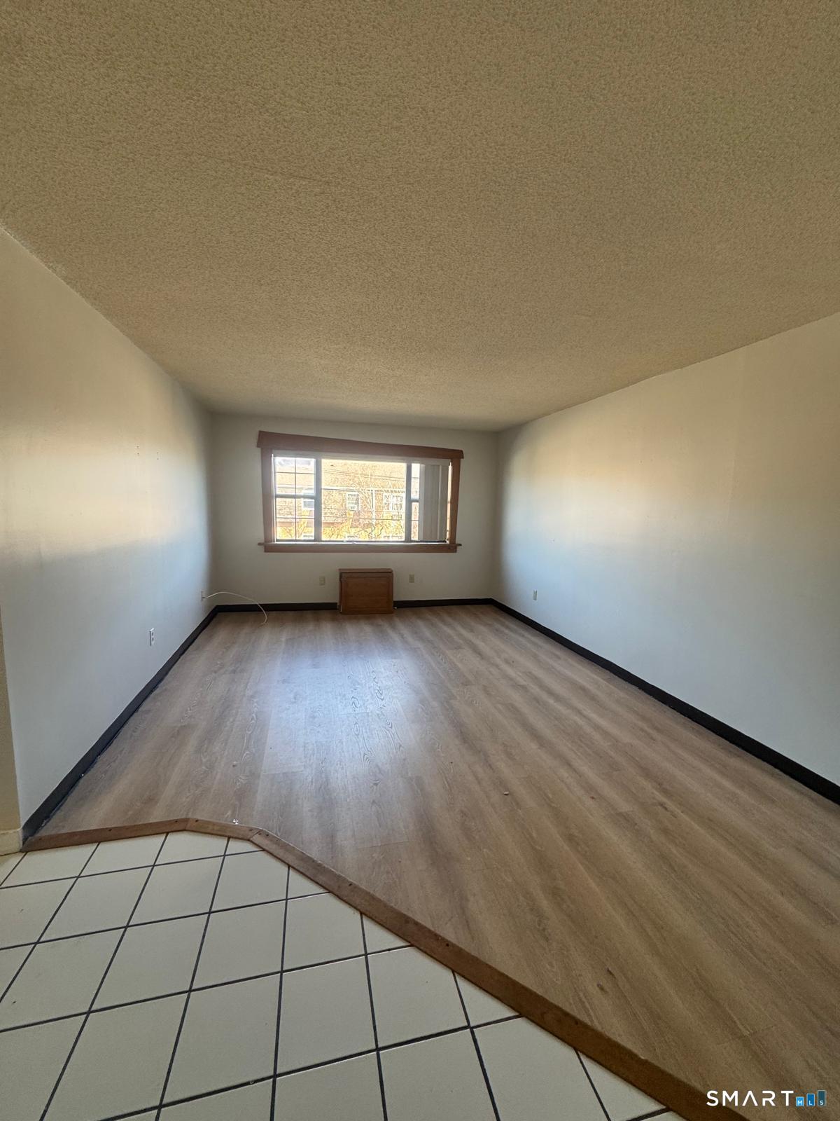 45 Stevens Street, Unit 5 Bridgeport, CT 06606 - Photo 4 of 8 wooden floor in an empty room with a window
