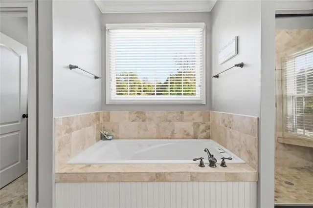 a kitchen with stainless steel appliances granite countertop a stove a sink dishwasher a refrigerator and white cabinets with wooden floor