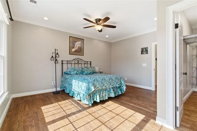 a view of a hallway with wooden floor and a potted plant