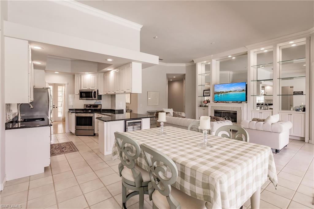 5163 Inagua Way Naples, FL 34119 - Photo 18 of 50 Tiled dining space with crown molding, wine cooler, and sink