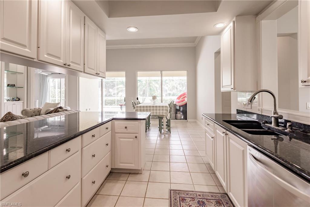 5163 Inagua Way Naples, FL 34119 - Photo 22 of 50 Kitchen featuring dishwasher, light tile patterned floors, sink, white cabinetry, and dark stone countertops