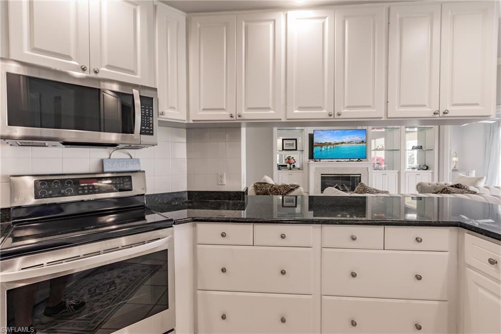 5163 Inagua Way Naples, FL 34119 - Photo 26 of 50 Kitchen with white cabinets, appliances with stainless steel finishes, and decorative backsplash