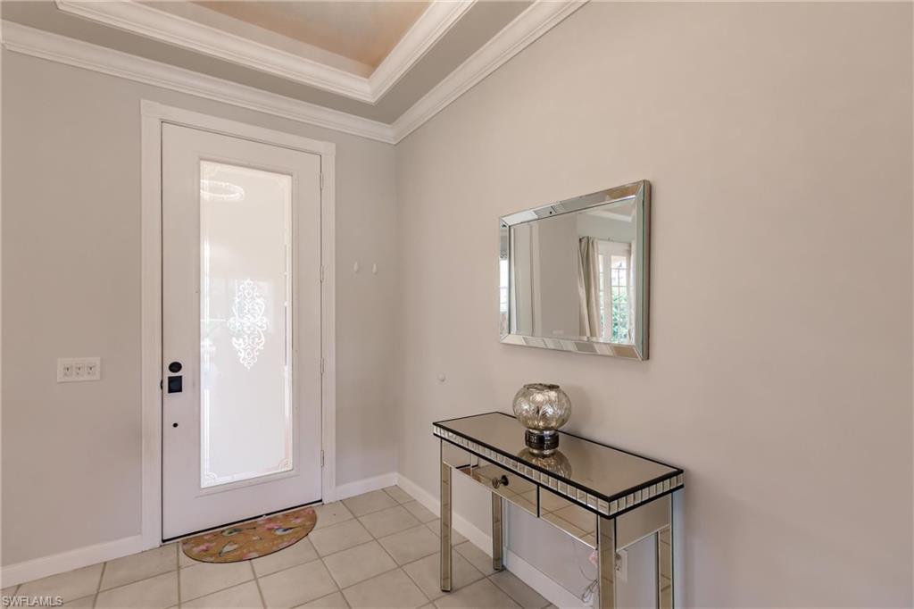 5163 Inagua Way Naples, FL 34119 - Photo 3 of 50 Entrance foyer with ornamental molding, a raised ceiling, and light tile patterned floors