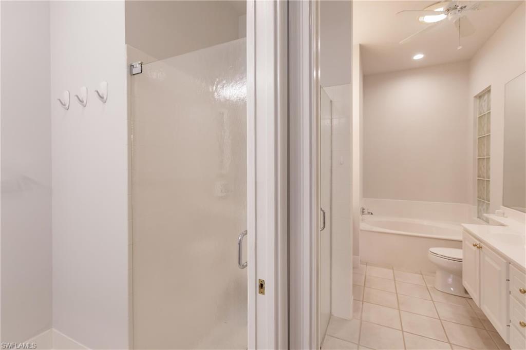 5163 Inagua Way Naples, FL 34119 - Photo 32 of 50 Full bathroom with vanity, separate shower and tub, ceiling fan, and tile patterned floors