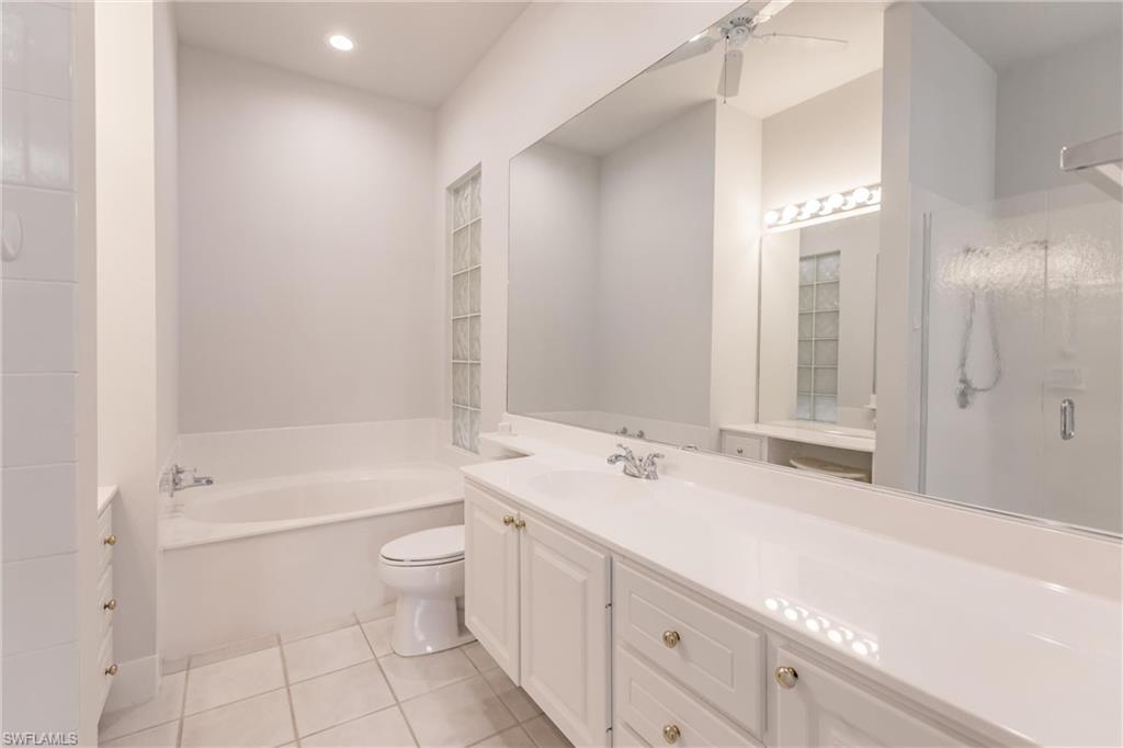 5163 Inagua Way Naples, FL 34119 - Photo 33 of 50 Full bathroom with toilet, plus walk in shower, tile patterned flooring, vanity, and ceiling fan