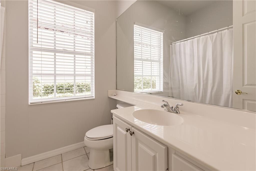 5163 Inagua Way Naples, FL 34119 - Photo 38 of 50 Bathroom with tile patterned floors, toilet, curtained shower, and vanity