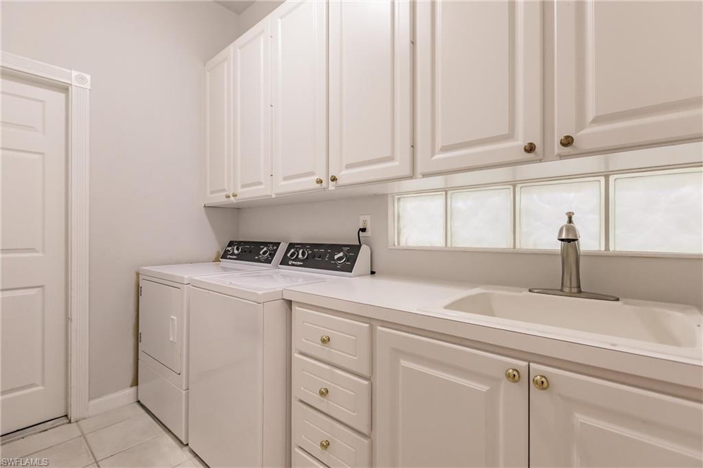 5163 Inagua Way Naples, FL 34119 - Photo 44 of 50 Clothes washing area with light tile patterned flooring, sink, cabinets, and separate washer and dryer