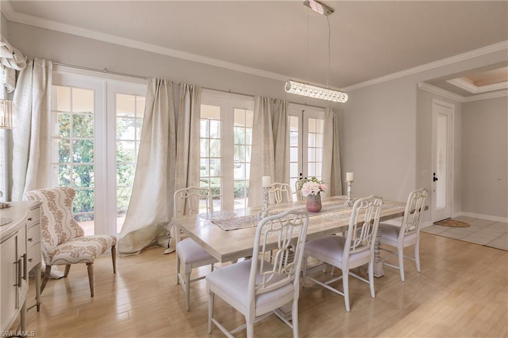 5163 Inagua Way Naples, FL 34119 - Photo 6 of 50 Dining area with crown molding, light hardwood / wood-style flooring, and french doors