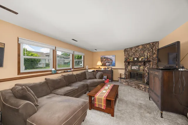 a living room with furniture a flat screen tv and a large window