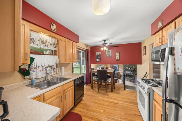 a kitchen with stainless steel appliances dining table chairs and a large window