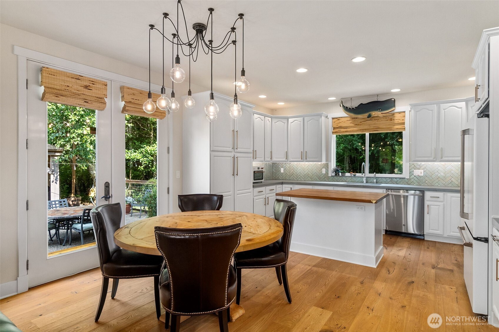 9044 Hunter Point Road Northwest Olympia, WA 98502 - Photo 14 of 40 a kitchen with a table chairs stove and wooden floor
