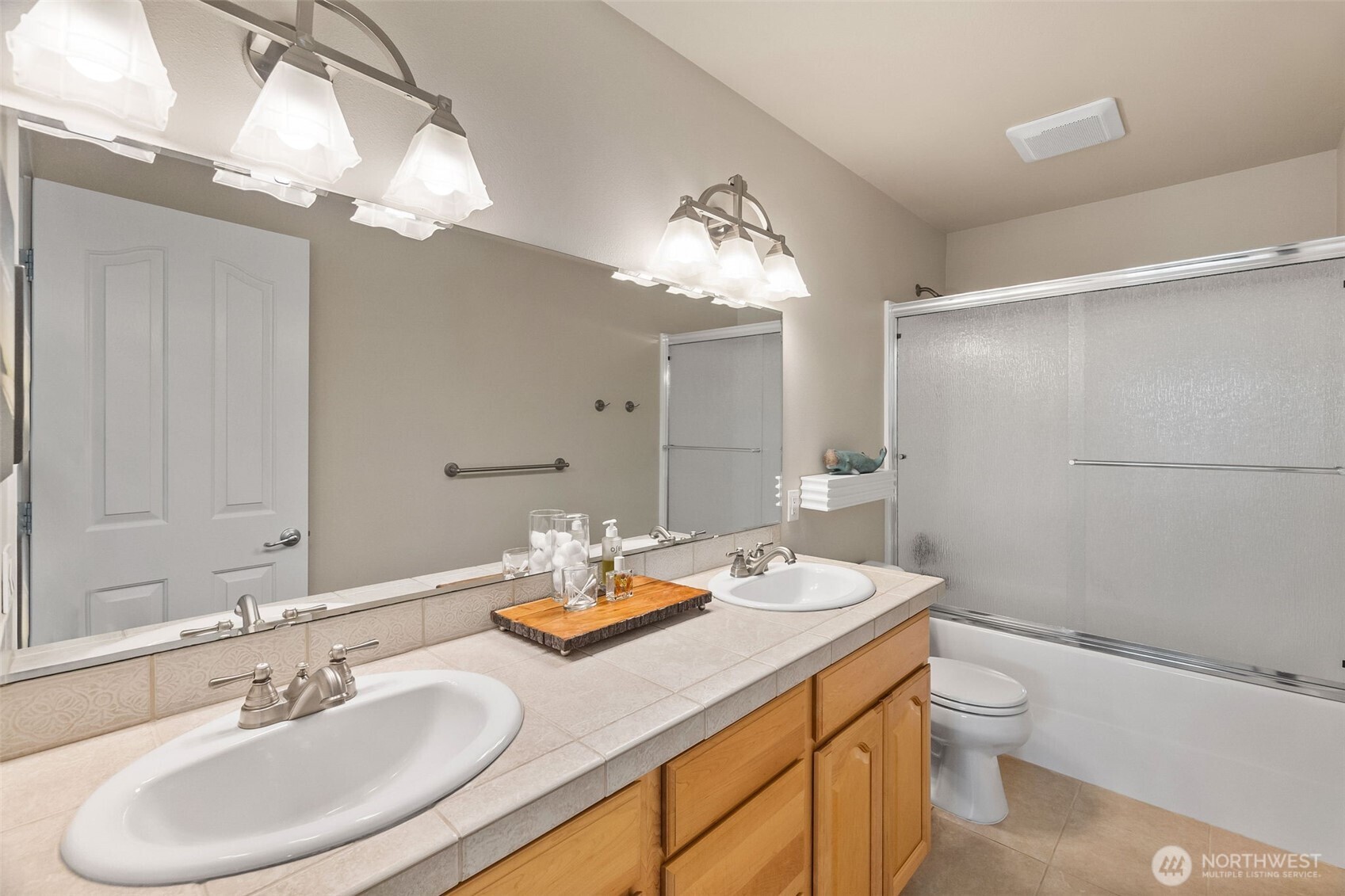 9044 Hunter Point Road Northwest Olympia, WA 98502 - Photo 23 of 40 a bathroom with a granite countertop sink toilet a large mirror and shower